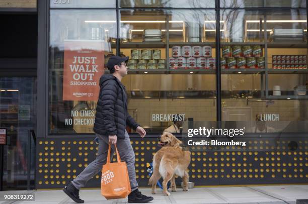 Pedestrian walks past a dog outside the Amazon Go store in Seattle, Washington, U.S., on Wednesday, Jan. 17, 2018. After more than a year of testing...