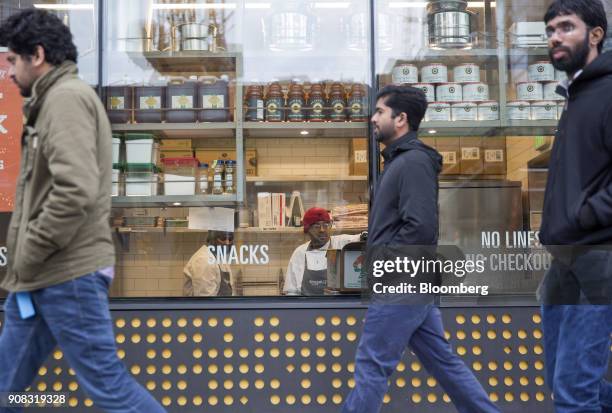 Pedestrians walk past the Amazon Go store in Seattle, Washington, U.S., on Wednesday, Jan. 17, 2018. After more than a year of testing with an...