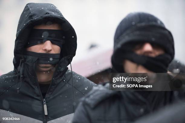 Men use black bands over their eyes and mouths during a silent assembly named Stolen Justice in Krakow. Stolen Justice happening, intend to express...