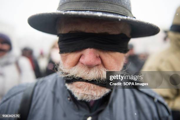 Man uses black bands over his eyes and mouth during a silent assembly named Stolen Justice in Krakow. Stolen Justice happening, intend to express...