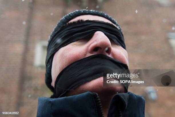 Man uses black bands over his eyes and mouth during a silent assembly named Stolen Justice in Krakow. Stolen Justice happening, intend to express...