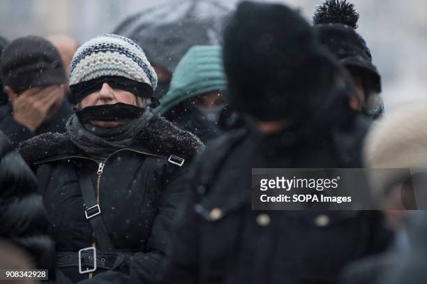People use black bands over their eyes and mouths during a silent assembly named Stolen Justice in Krakow. Stolen Justice happening, intend to...