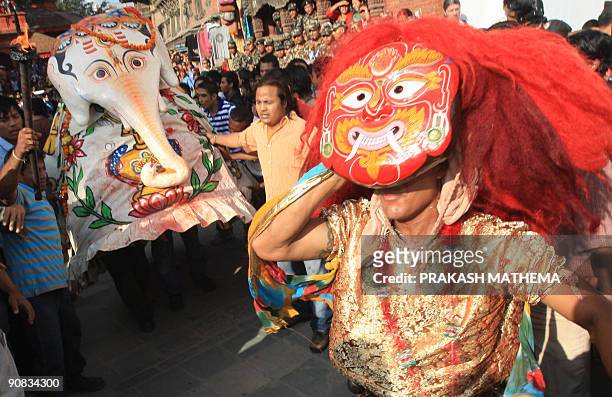 Nepalese masked dancers perform in the procession with the chariot of Kumari, the prepubescent girl revered in Nepal as a living goddess, during the...