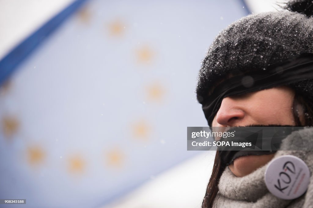 A woman uses black bands over her eyes and mouth with the EU...