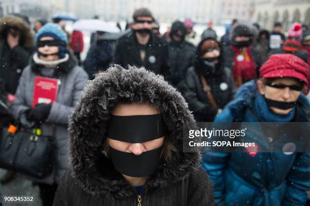 People use black bands over their eyes and mouths during a silent assembly named Stolen Justice in Krakow. Stolen Justice happening, intend to...