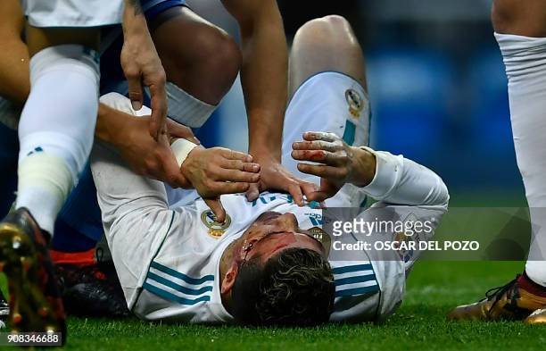 Real Madrid's Portuguese forward Cristiano Ronaldo lies on the field after sustaining an injury during the Spanish league football match between Real...