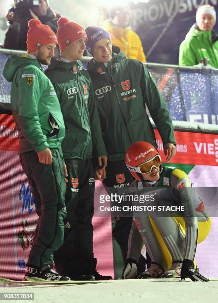 Members of the German team Andreas Wellinger, Markus Eisenbichler, Stephan Leyhe and Richard Freitag react after the last jump of the team...