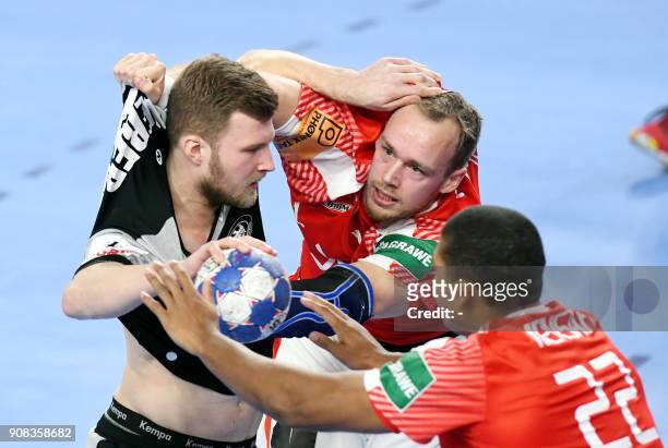 Germany's Philipp Weber vies with Denmark's Henrik Toft Hansen and Mads Mensah Larsen during the group II match of the Men's 2018 EHF European...