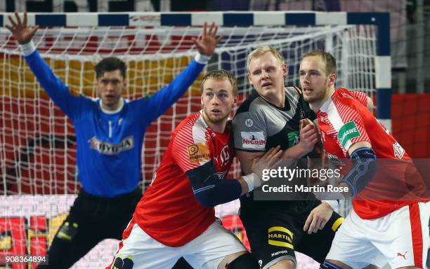 Patrick Wiencek of Germany between Rene Toft Hansen and Henrik Toft Hansen of Denmark during the Men's Handball European Championship main round...