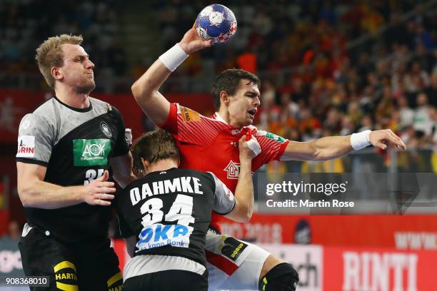 Rasmus Lauge Schmidt of Denmark is challenged by Rune Damke and Julius Kuehn of Germany during the Men's Handball European Championship main round...