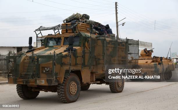 Turkish armoured personnel carriers and infantry fighting vehicles pass through the Bab al-Salamah border crossing between Syria and Turkey in the...