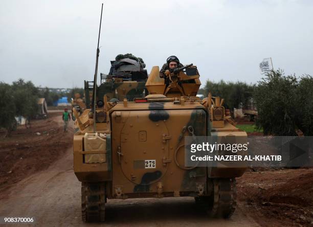 Turkish soldier mans a turret on an infantry fighting vehicle driving near the village of Yazi Bagh, about six kilometres from the Bab al-Salamah...