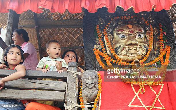 Nepalese Hindu women and children watch the Indra Jatra festival at Basantapur Durbar Square in Kathmandu on September 3, 2009. Nepal's week-long...