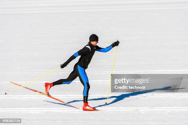 seitenansicht der langläuferin läuft in klassischen skitechnik - langlaufen stock-fotos und bilder