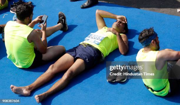 Participants relax near the finish line after Mumbai Marathon near CST station on January 21, 2018 in Mumbai, India.