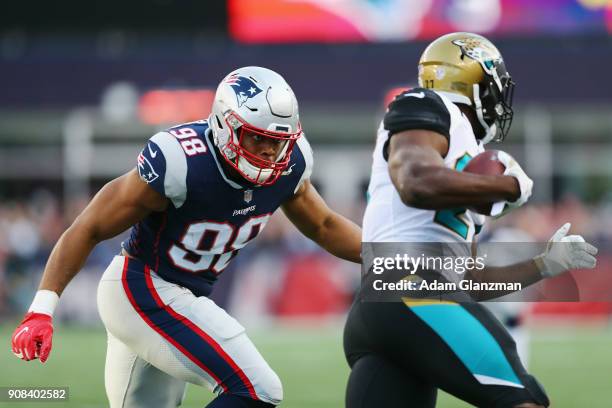 Leonard Fournette of the Jacksonville Jaguars carries the ball as he is defended by Trey Flowers of the New England Patriots in the first quarter...