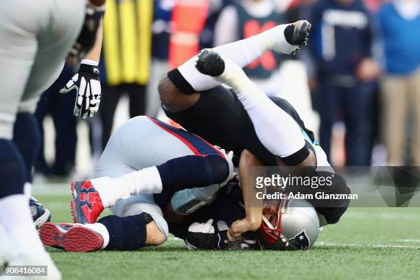 Tom Brady of the New England Patriots is tackled by Dante Fowler of the Jacksonville Jaguars in the second quarter during the AFC Championship Game...
