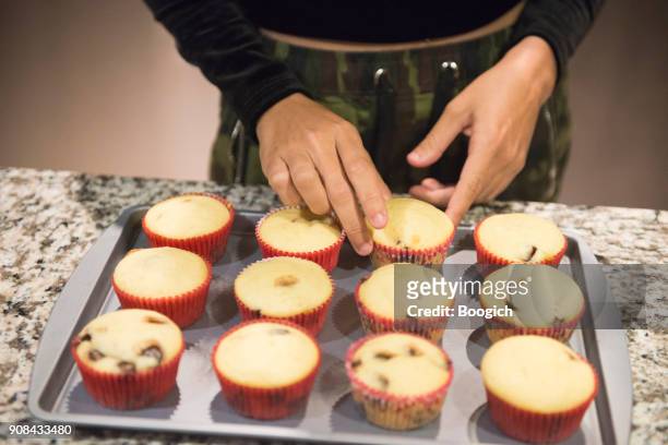 tausendjährigen hispanic frau arrangieren gebackene muffins am hause orlando usa - hot puerto rican women stock-fotos und bilder