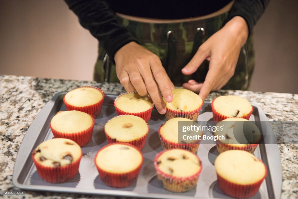 Millennial Hispanic Woman Arranging Baked Cupcakes at Home Orlando USA