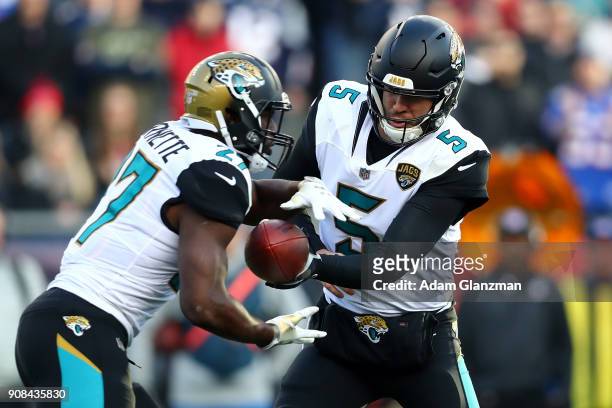 Blake Bortles of the Jacksonville Jaguars hands the ball offsides to Leonard Fournette in the second half during the AFC Championship Game against...