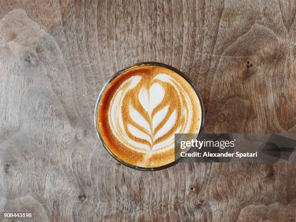 cup of coffee with beautiful latte art on the wooden table - latte stock pictures, royalty-free photos & images