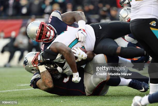 Leonard Fournette of the Jacksonville Jaguars is tackled in the firs thalf during the AFC Championship Game against the New England Patriots at...