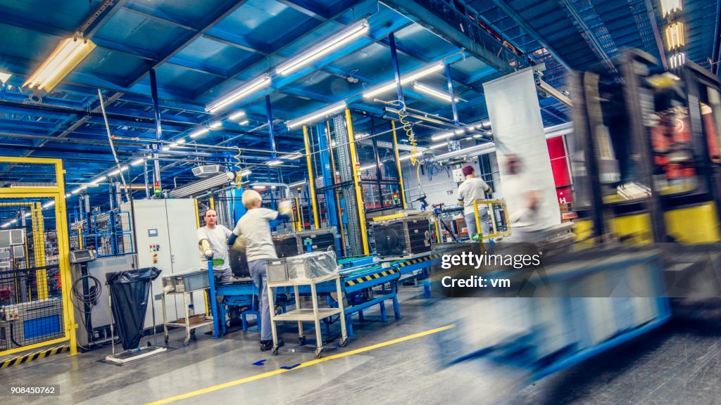 Blurred forklift and factory workers