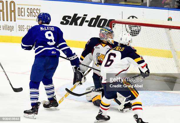 Michael McLeod of the Mississauga Steelheads tips in a goal past goalie Kai Edmonds and Victor Hadfield of the Barrie Colts during OHL game action on...