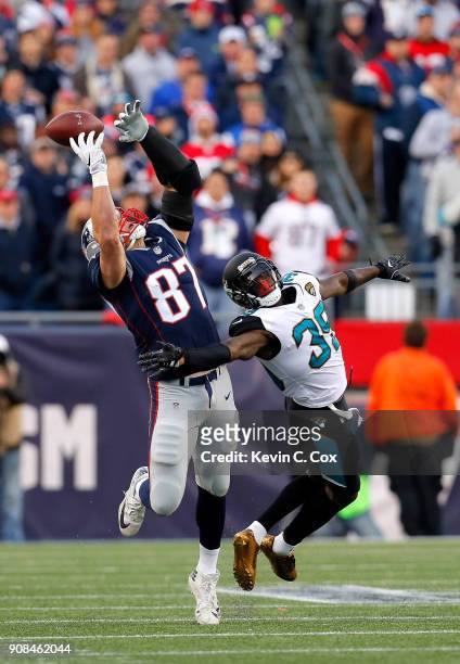 Rob Gronkowski of the New England Patriots attempts a catch as he is defended by Tashaun Gipson of the Jacksonville Jaguars in the first half during...