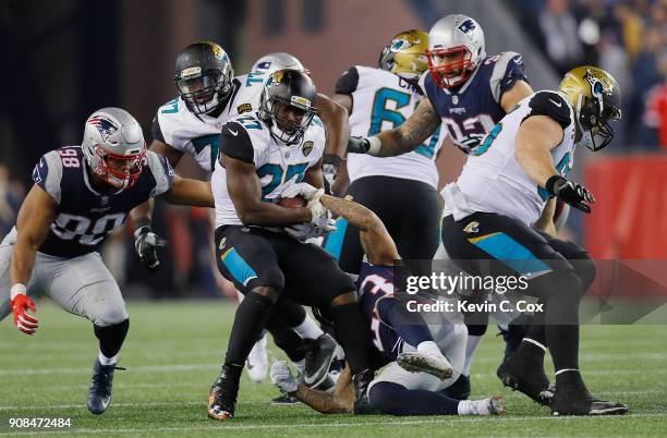 Leonard Fournette of the Jacksonville Jaguars is tackled as he carries the ball in the second half during the AFC Championship Game against the...