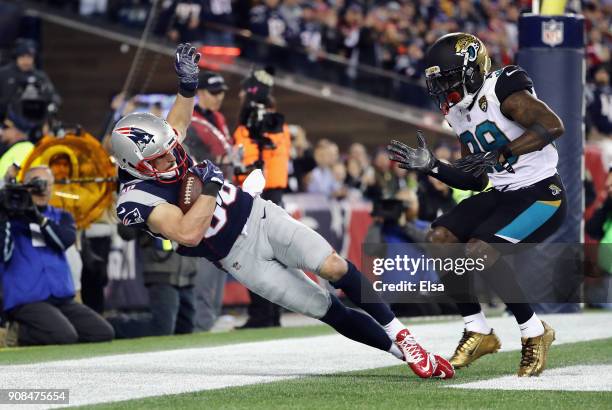 Danny Amendola of the New England Patriots catches a touchdown pass as he is defended by Tashaun Gipson of the Jacksonville Jaguars in the fourth...