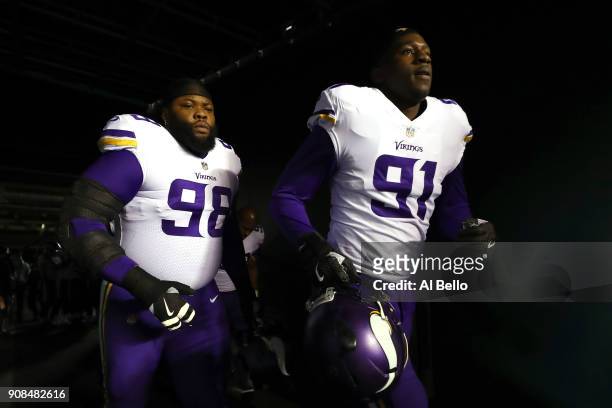 Linval Joseph and Stephen Weatherly of the Minnesota Vikings walk out on the field for warm ups prior to the NFC Championship game against the...