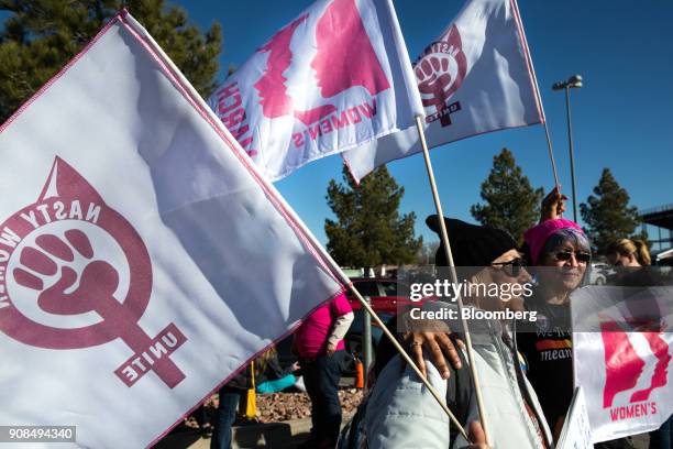 Attendees hold women's rights flags outside before entering the Sam Boyd Stadium during the Women's March One-Year Anniversary: Power To The Polls...