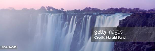 panoramic evening view of the zambezi river cascading over victoria falls. victoria falls national park. - victoria falls national park stock pictures, royalty-free photos & images