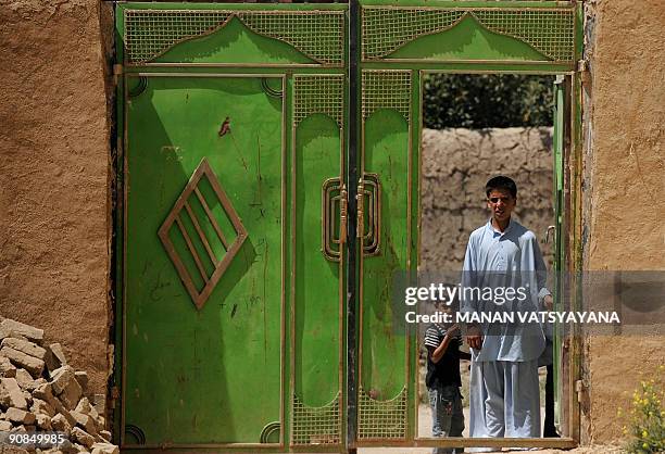 Afghan children look past a gate as unseen US soldiers from the 1st Platoon Alpha 3-71 Cavalry secure the area during a mission at a village in the...