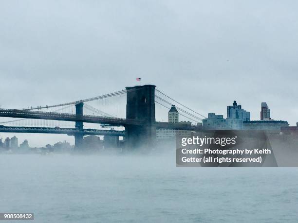 winter fog surrounding the brooklyn bridge creating a white landscape - brooklyn bridge winter stock pictures, royalty-free photos & images