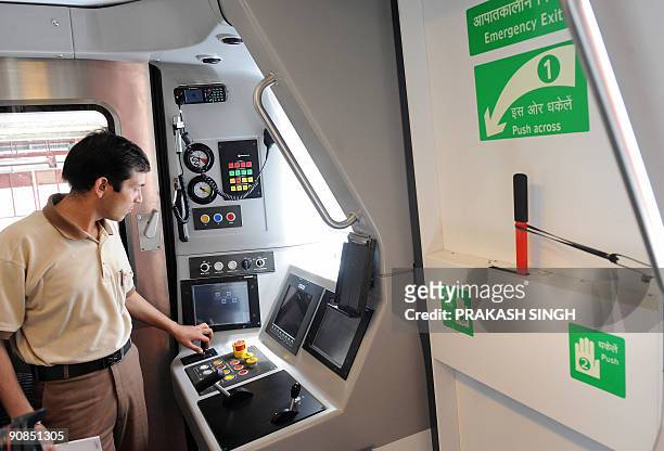 Metro employee briefs journalists from the driver's cabin of a Delhi Metro new broad gauge train manufactured by Bombardier during a preview in New...