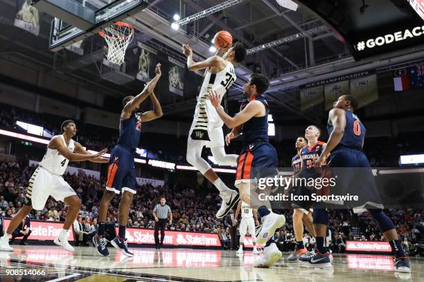 Wake Forest Demon Deacons center Olivier Sarr goes up for a shot over Virginia Cavaliers forward Isaiah Wilkins during the ACC matchup on January 21,...