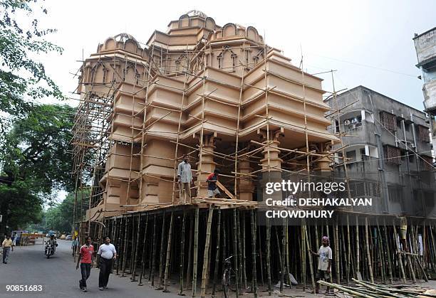 Indian workers prepare a makeshift Durga temple based on the famous Hindu temple of Akshardham in Kolkata on September 16, 2009. Durga Puja, the...