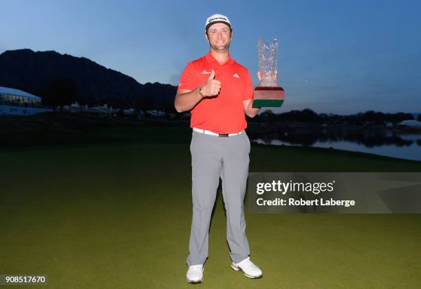 Jon Rahm of Spain poses with the trophy after putting in to win on the fourth hole of a sudden death playoff during the final round of the...