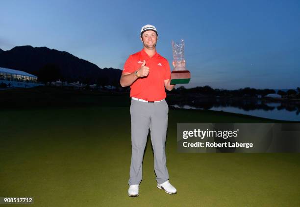 Jon Rahm of Spain poses with the trophy after putting in to win on the fourth hole of a sudden death playoff during the final round of the...