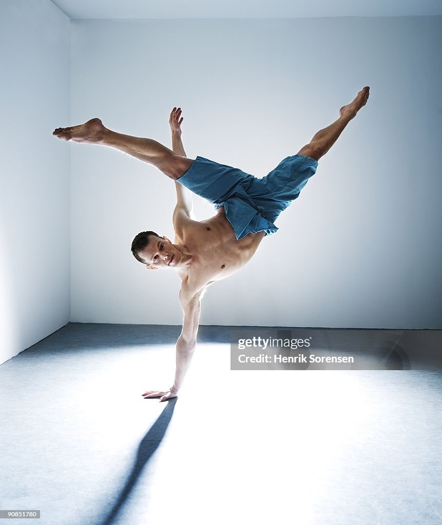 Young male dancer on one hand