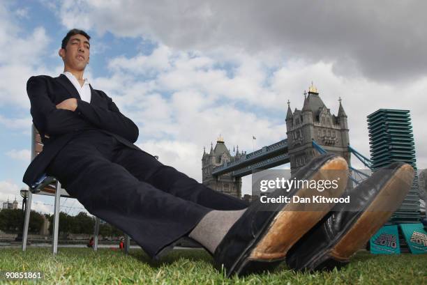 The worlds new tallest man Sultan Kosen 26, of Turkey poses in front of Tower Bridge to celebrate the launch of the 2010 Guinness Book of Records, on...