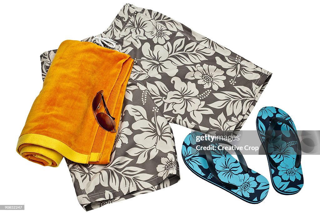 Men's beach shorts, flip flips, towel and sunglass