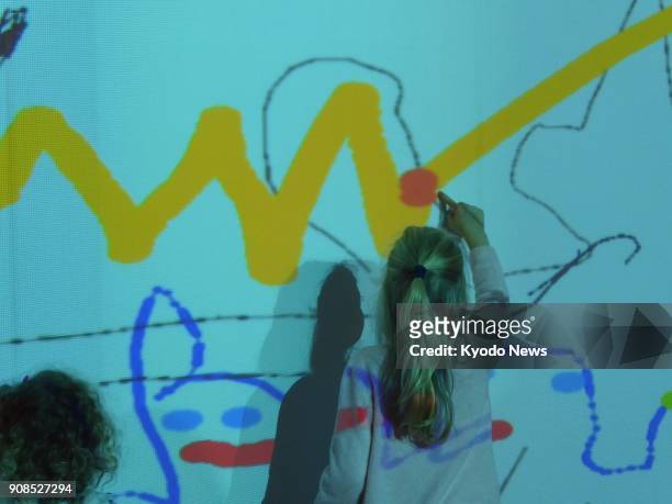 Young girl participates in Join the Dots, an interactive, digital art project that allows children in Sydney and Japan's Ota city to create art...