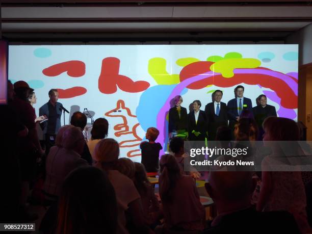 Dignitaries and speakers gather for a photo in front of a projected art work created during Join the Dots at the Sydney Opera House on Jan. 16, 2018....