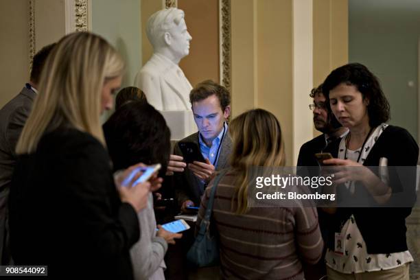 Members of the media listen on their mobile devices to Senate Majority Leader Mitch McConnell, a Republican from Kentucky, speaking on the Senate...