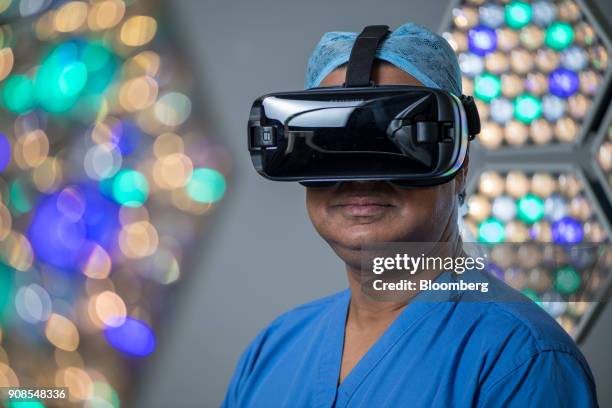 Surgeon Shafi Ahmed poses for a photograph wearing a Samsung Electronics Co. Gear VR headset inside his operating theater at the Royal London...