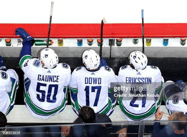 Brendan Gaunce, Nic Dowd and Loui Eriksson of the Vancouver Canucks look on from the bench during second period action against the Winnipeg Jets at...