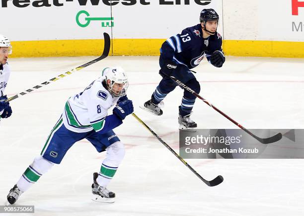 Christopher Tanev of the Vancouver Canucks and Brandon Tanev of the Winnipeg Jets follow the play up the ice during third period action at the Bell...